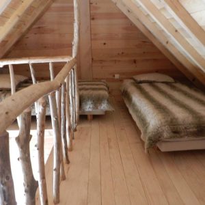 Chalet en bois dans les combles, avec lits douillets et décor naturel.