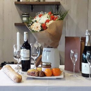 Hébergement insolite en Languedoc-Roussillon, table dressée avec fleurs et vins.