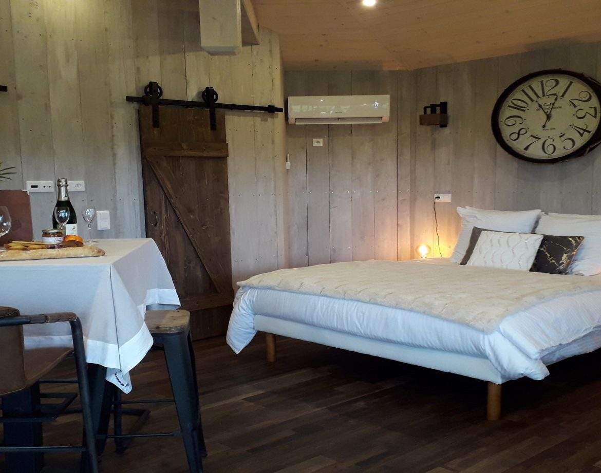 Chalet moderne en bois avec lit douillet et coin repas romantique.