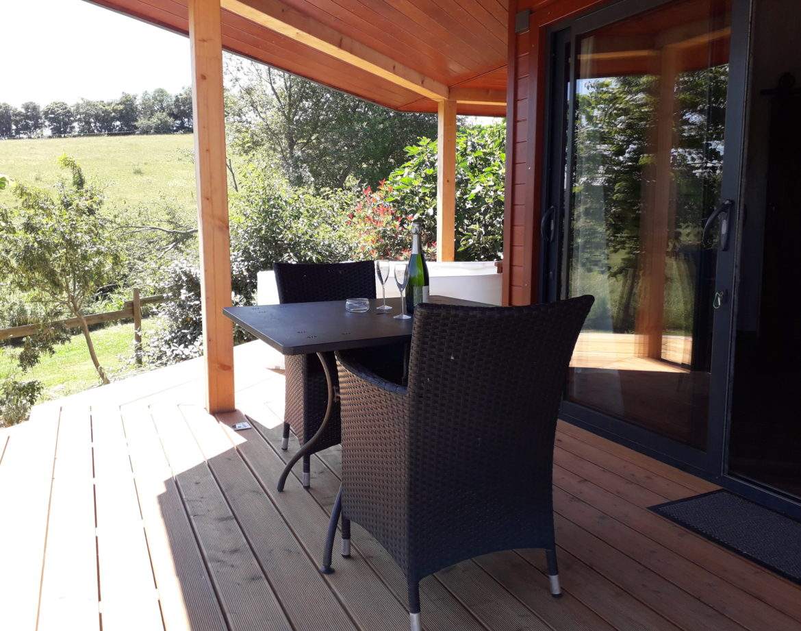 Hébergement insolite en Languedoc-Roussillon, terrasse en bois avec vue verdoyante.
