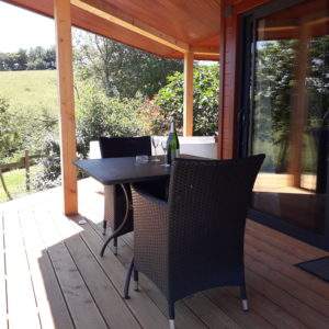 Hébergement insolite en Languedoc-Roussillon, terrasse en bois avec vue verdoyante.