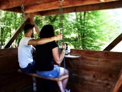 Cabane perchée en Auvergne-Rhône-Alpes, avec balançoire en bois et vue sur la nature.