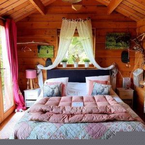 Cabane en bois cosy avec lit douillet et décoration chaleureuse. Parfaite pour un séjour nature.