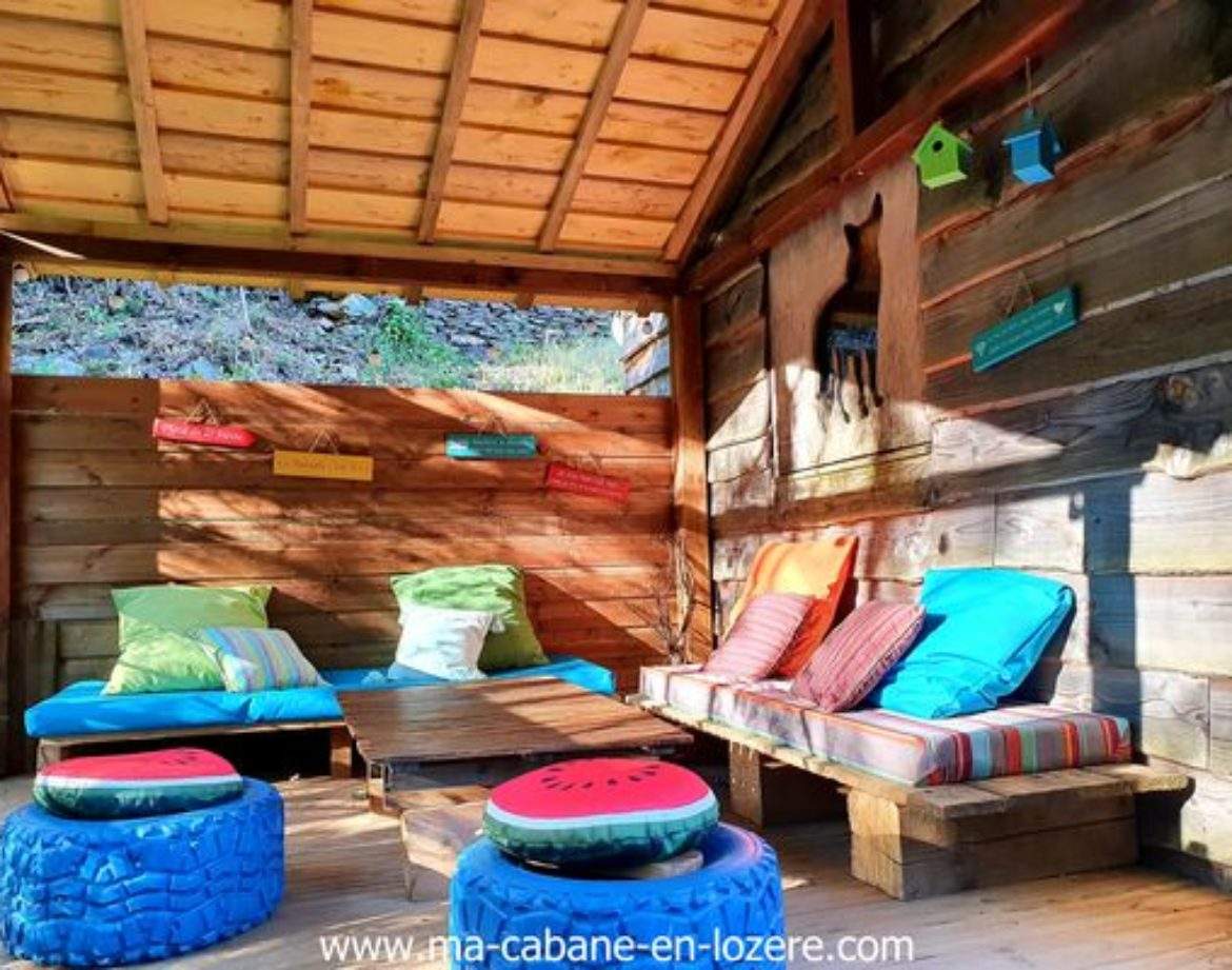 Cabane en bois colorée avec coussins confortables et décoration originale.