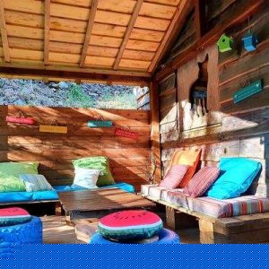 Cabane en bois colorée avec coussins confortables et décoration originale.