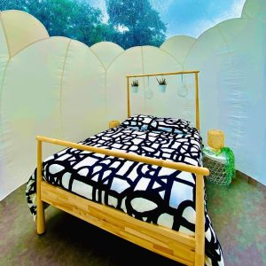 Hébergement insolite en bulle à Basse-Normandie avec lit en bois et décor moderne.