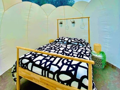 Hébergement insolite en bulle à Basse-Normandie avec lit en bois et décor moderne.