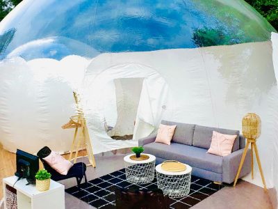 Hébergement insolite en bulle transparente, salon moderne et cosy au cœur de la nature.