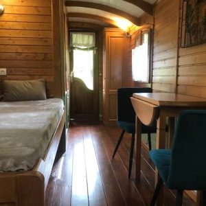 Hébergement insolite : roulotte en bois avec un intérieur chaleureux et lumineux.