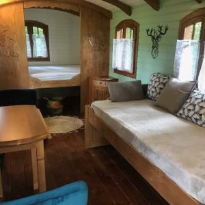 Hébergement insolite en cabane avec lit confortable et fenêtres lumineuses.