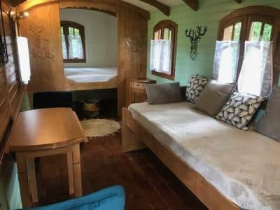 Hébergement insolite en cabane avec lit confortable et fenêtres lumineuses.