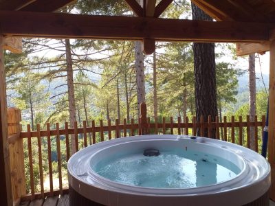 Cabane en bois avec jacuzzi, offrant une vue imprenable sur la forêt en Auvergne-Rhône-Alpes.