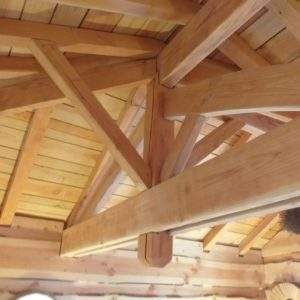 Intérieur dun chalet en bois, avec une belle charpente apparente et chaleureuse.