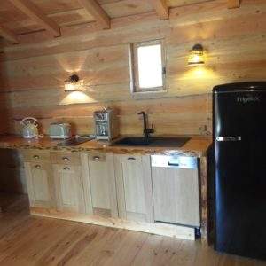 Cuisine en bois dans un chalet insolite en Auvergne-Rhône-Alpes, ambiance chaleureuse.