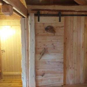 Cabane en bois avec une porte coulissante, ambiance chaleureuse et naturelle.
