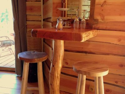 Hébergement insolite en Auvergne-Rhône-Alpes, intérieur en bois avec table et tabourets rustiques.