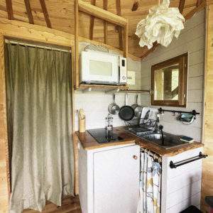 Cabane en bois cosy avec kitchenette et décoration chaleureuse dans les Pays de la Loire.