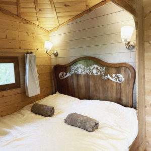 Cabane en bois cosy avec lit douillet et décoration élégante à Pays de la Loire.