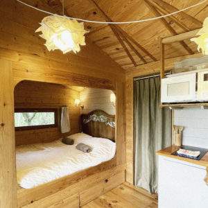 Cabane en bois cosy avec lit douillet et décoration chaleureuse.