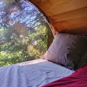 Hébergement insolite en cabane avec vue sur la nature depuis un grand hublot.