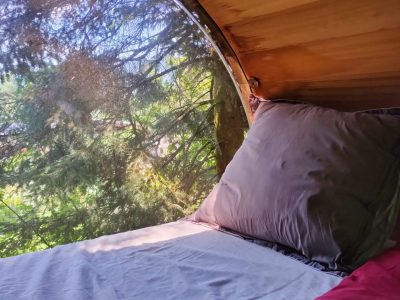 Hébergement insolite en cabane avec vue sur la nature depuis un grand hublot.
