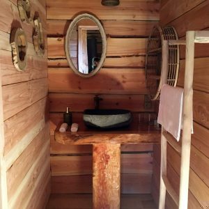 Salle de bain en bois dans un hébergement insolite en Auvergne-Rhône-Alpes.