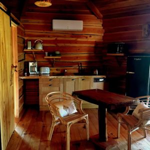 Cabane en bois en Auvergne-Rhône-Alpes, avec cuisine équipée et mobilier chaleureux.