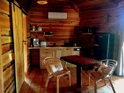 Cabane en bois en Auvergne-Rhône-Alpes, avec cuisine équipée et mobilier chaleureux.