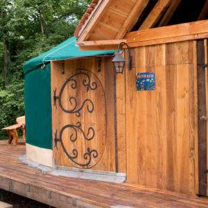 Yourte en bois à Bourgogne, avec une terrasse en bois et des sculptures en bois.