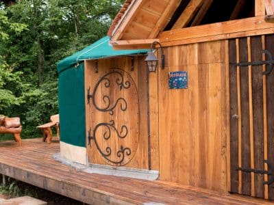 Yourte en bois à Bourgogne, avec une terrasse en bois et des sculptures en bois.