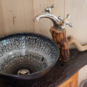 Évier en céramique dans un hébergement insolite en Bourgogne, ambiance chaleureuse.