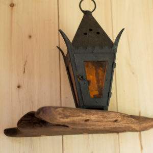 Lanterne vintage en métal sur étagère en bois dans un hébergement insolite en Bourgogne.