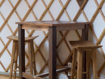 Yourte en Bourgogne avec un bar en bois et des tabourets élégants.