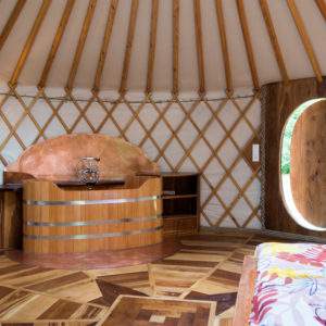 Yourte en Bourgogne avec un intérieur en bois chaleureux et un coin salon accueillant.