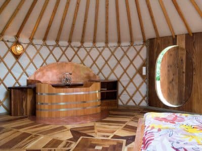 Yourte en Bourgogne avec un intérieur en bois chaleureux et un coin salon accueillant.