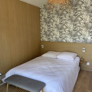 Chambre dhôte moderne en Aquitaine avec un éclairage en osier et décor floral.