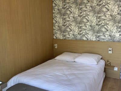 Chambre dhôte moderne en Aquitaine avec un éclairage en osier et décor floral.
