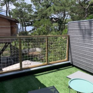 Cabane perchée en Aquitaine avec terrasse verdoyante et vue sur la nature.