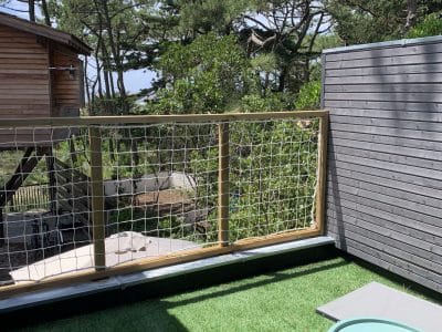 Cabane perchée en Aquitaine avec terrasse verdoyante et vue sur la nature.