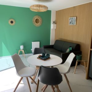 Hébergement insolite en Aquitaine : intérieur moderne avec murs verts et mobilier scandinave.