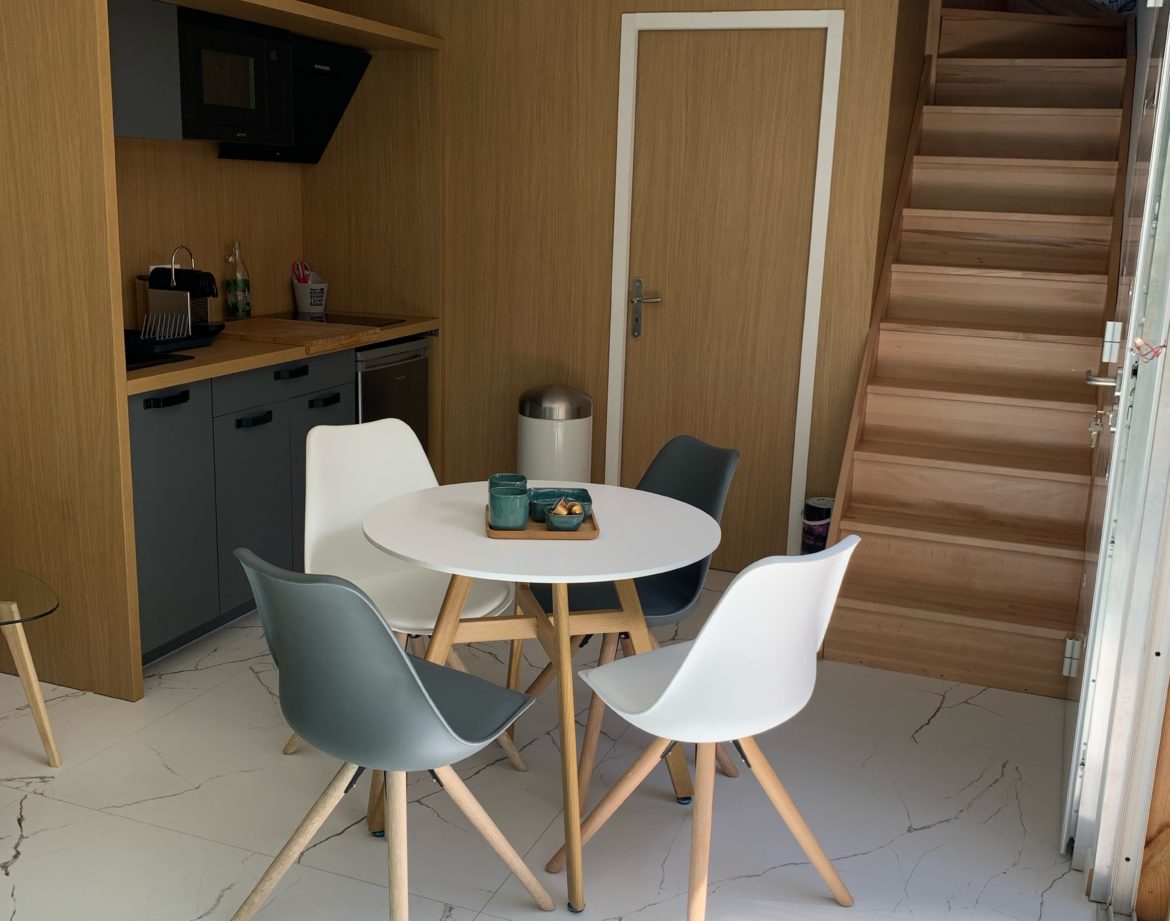 Hébergement insolite en Aquitaine : charmant loft avec cuisine moderne et escalier en bois.
