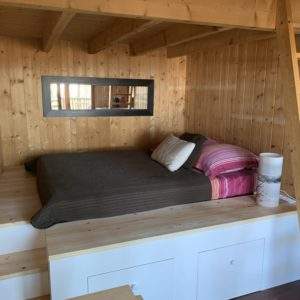 Chalet en bois avec lit douillet et décoration chaleureuse en Aquitaine.