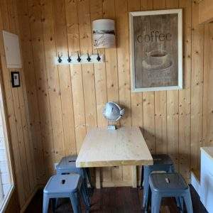 Cabane en bois en Aquitaine, avec une table en bois et des chaises métalliques.