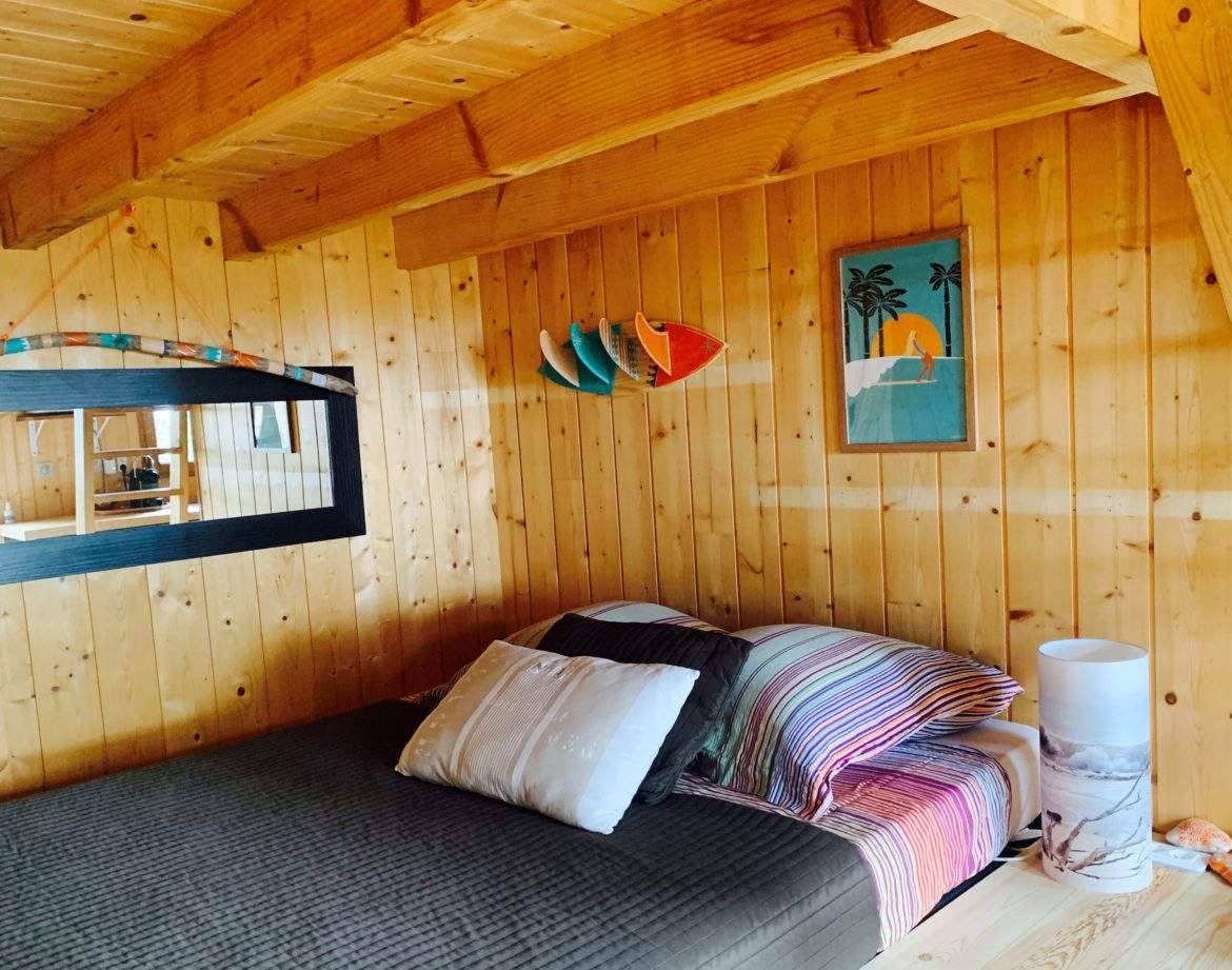 Cabane en bois chaleureuse avec lit douillet et décor coloré.