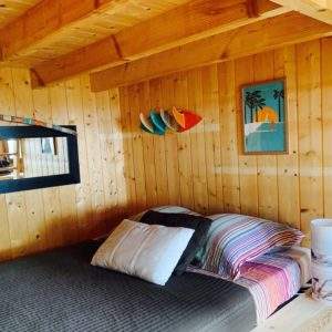Cabane en bois chaleureuse avec lit douillet et décor coloré.