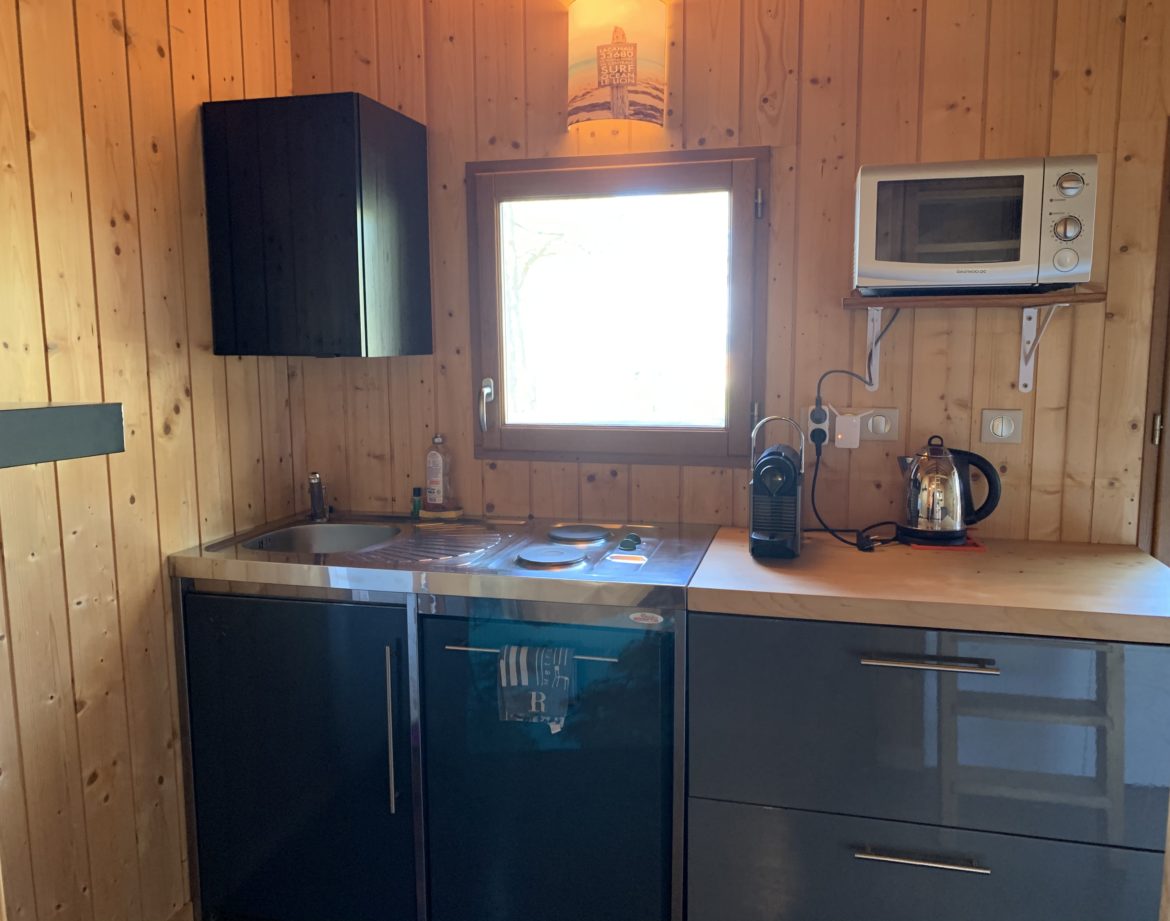 Cottage en bois en Aquitaine, avec cuisine moderne et fenêtre lumineuse.