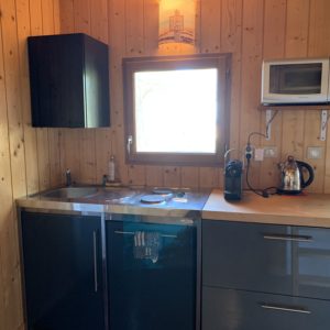Cottage en bois en Aquitaine, avec cuisine moderne et fenêtre lumineuse.