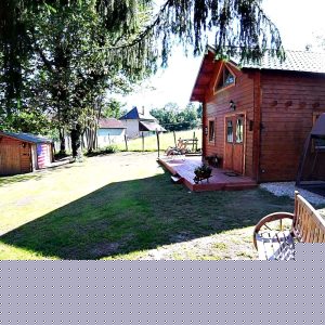 Charmant chalet en bois dans un cadre verdoyant, avec terrasse et banc en extérieur.