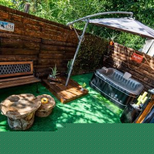 Hébergement insolite en Auvergne-Rhône-Alpes avec jacuzzi et coin détente en bois.