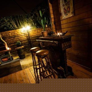 Hébergement insolite en bois avec bar et éclairage chaleureux, idéal pour des soirées conviviales.